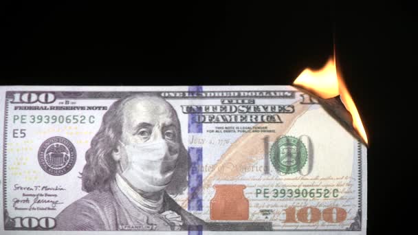 One hundred usd dollar bill with protective medical mask on Benjamin Franklin portrait burning from fire. Economic Crisis during Covid-19 Pandemic concept. 100 dollar banknote. 4k high quality video — Stock Video
