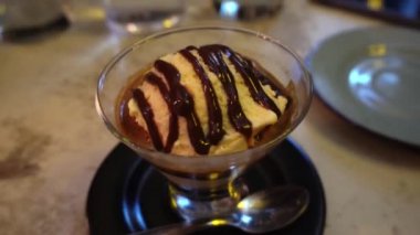 Bir kahvecinin cam bardağındaki dondurmalı kahvenin yakın çekimi.