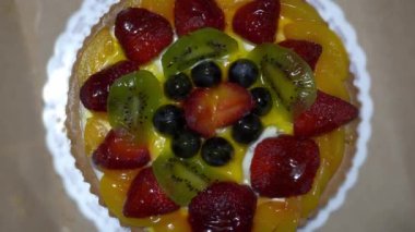 Çilekli, üzümlü ve kivili turtalı kekin üst görüntüsü.