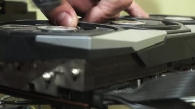 Elektrik üfleyicisiyle şifreli bir madencilik PC grafik kartının tozunu alıyorum.