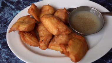 4K 'da bir Peru Chifa restoranında, beyaz tabakta nefis bir domuz derisi tabağına yakın plan.