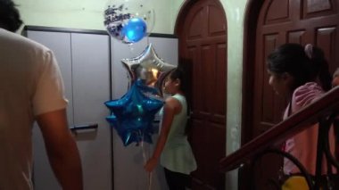Yeğenlerin büyükbabalarını doğum gününde balonlarla selamlamaları ve heyecanlı ve mutlu olmaları.