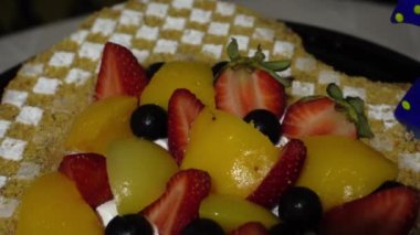 Kalp şeklinde bir kekin yakın çekimi. Çilekli, şeftalili ve kremalı doğum günü pastası.