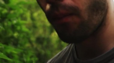 Bir adamın ağzının kapanışı ızgarada tavuk kanadı yemek ve gündüzleri dans etmek.