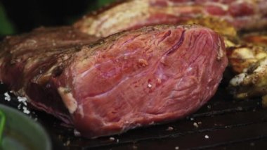 Picanha bifteği ızgarada pişerken ve arkadaşlarıyla birlikte bir kır evinde kırmızı ve pembeye dönerken yakın çekim.