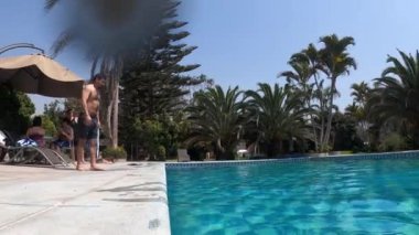 Bir adam havuza atlıyor ve arkadaşı onu korkutuyor. Sonra da güpegündüz palmiye ağaçlarıyla dolu bir kır evine atlıyor.