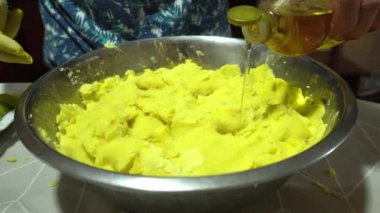 4 km uzunluğunda Peru yemekleri olan Lima 'dan gelen Causas' ı hazırlamak için bir kase dolusu sarı patatese yakın çekim yağı dökülüyor.