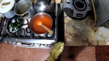 POV 'un yakın plan görüntüsü haşlanmış sıcak yulaf lapasını çömlekten cam konteynıra boşaltarak gece 4 km' de mutfakta serinletiyor.