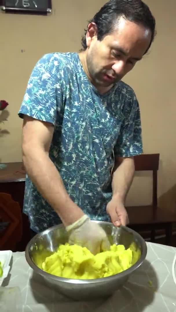 전형적 음식인 카사스 리마를 준비하기 용기에 노란색 감자를 남자의 — 비디오