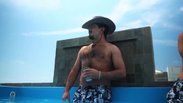 Człowiek Kapeluszu Pijący Piwo Wypływem Zimnej Wody Basenu Basenie Tarasie — Wideo stockowe