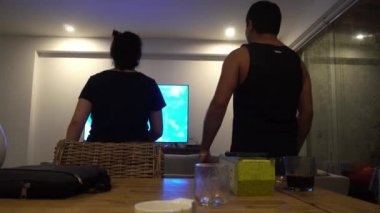 Bir düğün çifti, gece 4K 'de bir sahil evinin oturma odasında televizyon koreografisini takip ediyor.