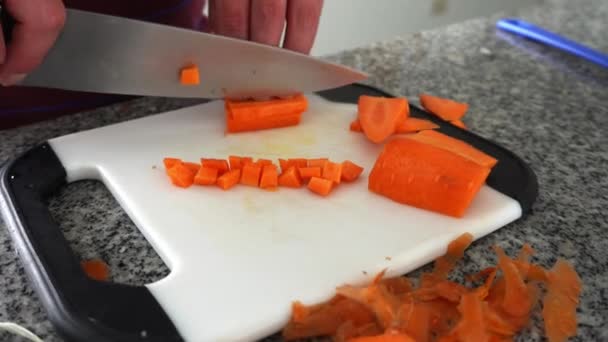 Крупным Планом Руки Белого Человека Разрезающего Морковку Маленькие Квадратики Ножом — стоковое видео
