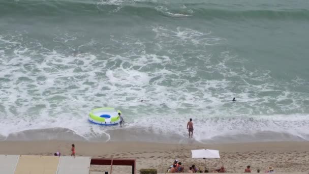 Kilka Osób Brzegu Plaży Bawi Się Platformą Falach Siedzi Piasku — Wideo stockowe