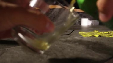 Kapalı çekimde cam bardağa konserve bira doldururken elleri ve çatıdan dökülen biralar gece 4K 'da.