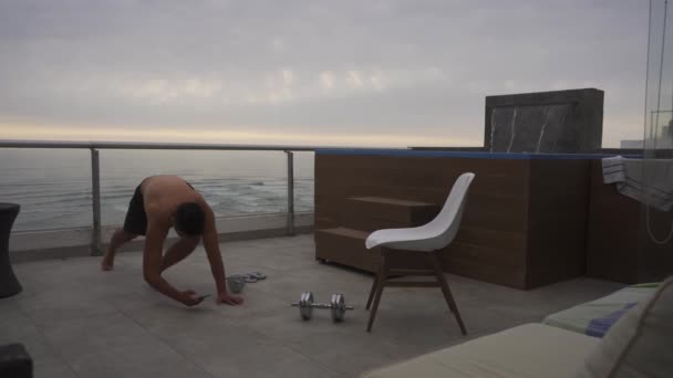 Man Doing Planks Timing His Watch Terrace Dumbbells Floor Beach — Vídeo de stock