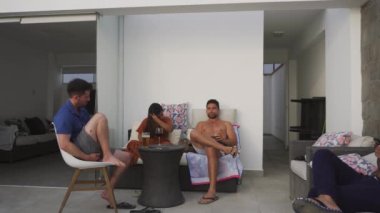Birkaç arkadaş bir sahil evinin terasında sohbet ediyor, gülüyor, bira ve şarap içiyor.