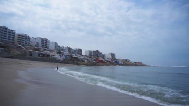 Gündüz vakti denize giren tanınamaz bir çift sevgili. Punta Hermosa, Lima, Peru 'daki sahilde bir kadın ve bir erkek.