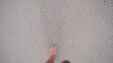 POV 'un gündüz vakti çıplak ayakla kumda geriye doğru yürürken gördüğü ilk kişi.