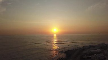 4k 'da bulutlu bir günde Punta Hermosa, Lima, Peru' da ilerleyen güzel bir gün batımının hava aracı görüntüsü.
