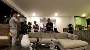 Arkadaşların hızlı kamerası, erkeklerin bir plaj evinde buluşması, içki içmesi ve televizyon izlemesi oturma odasında dans etmesi ve 4K 'da parti yapması.