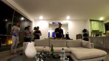 Arkadaşların hızlı kamerası, erkeklerin bir plaj evinde buluşması, içki içmesi ve televizyon izlemesi oturma odasında dans etmesi ve 4K 'da parti yapması.