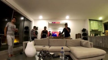 Arkadaşların hızlı kamerası, erkeklerin bir plaj evinde buluşması, içki içmesi ve televizyon izlemesi oturma odasında dans etmesi ve 4K 'da parti yapması.