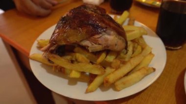 Izgara tavuk ve patates kızartmasıyla yakın plan, tipik Peru yemeği.