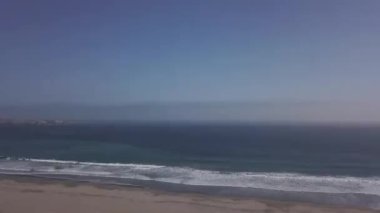 Çok güzel bir turkuaz plajın hava aracı görüntüsü, sahil şeridinde deniz ve gün içinde dalgalarla dönen bakir sular.