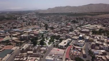 Yanı başında nehirler, tepeler, çöller ve kum tepeleri olan ve Casma Meydanı, Lima, Peru 'da açık gökyüzü olan bir şehrin insansız hava aracının uydu görüntüsü.