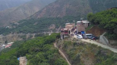 San Mateo de Otao dağlarındaki yeşil ağaçlı dağların arasında, teleferik gezisi yapan bir kasabanın hava aracı görüntüsü 4K 'da.