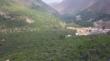 4k 'da, San Mateo de Otao dağlarındaki yeşil ağaçlı dağların arasındaki bir kasabada yapılan teleferik gezisinin ardından gelen insansız hava aracı görüntüsü.