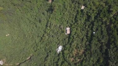 Beyaz bir teleferiğin hava aracı görüntüsü bir sürü bitki örtüsü ve dağların arasından geçen bir nehir San Mateo de Otao dağlarında yeşil ağaçlar arasında bir gün kuş bakışı bakıyor.