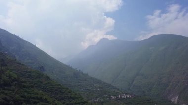 4k 'da, San Mateo de Otao dağlarında bir sürü bitki örtüsü arasında yol üzerinde yeşil ağaçlı dağların hava aracı görüntüsü.