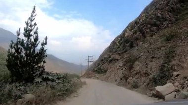 Arabadaki POV dağlık bölgelerdeki patika yolu boyunca ilerliyor ve yüksek voltaj kabloları ve antenleri olan yeşil ağaçlar gün içinde görüş açısında.