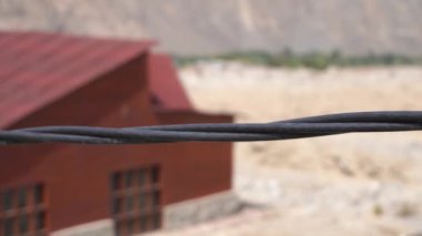 Siyah bir elektrik kablosunu takip ederek dağlarla nehir arasında asılı güzel bir manzara ve aynı gün içinde Lunahuana 'nın dağlık kesimlerinde mahsuller arasında sarkan bir kablo.