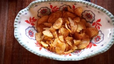 Yakın çekim görüntüsü aynı anda birden fazla elle paketlenmiş patates cipsini kapıyor.