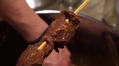 Pişirmeden önce baharatlı ahşap bir şişe çiğ anticucho şiş koymak, tipik Peru yemeği.