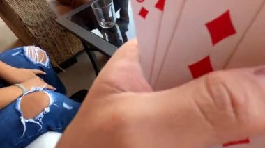 Pov arkadaşlarıyla kağıt oynuyor ve güneşli bir günde dağlardaki dağlarda açık mavi gökyüzü olan bir yazlıkta içki içiyor.