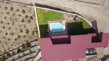 Havadan insansız hava aracı, arkadaşları üzerinde havuzda tatil yaparken Lunahuana, Peru 'nun dağlık kesimlerinde ızgarası olan bir kır evinde günün 4k kuşunun gözünden görülüyor.