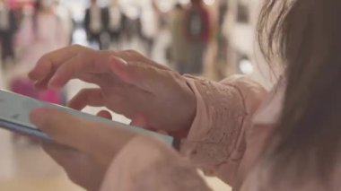 Mobil akıllı saati elinde tutan genç bir kadın.