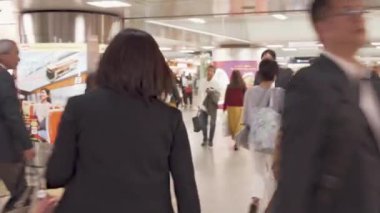 Kalabalık maske takıyor, kalabalık saatlerde şehirde yürüyor.