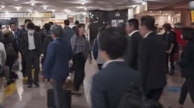 Kalabalık maske takıyor, kalabalık saatlerde şehirde yürüyor.