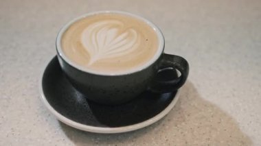 Barista 'nın bir fincan vejetaryen soya kahveli latte sanatı yaparken ki resmi.
