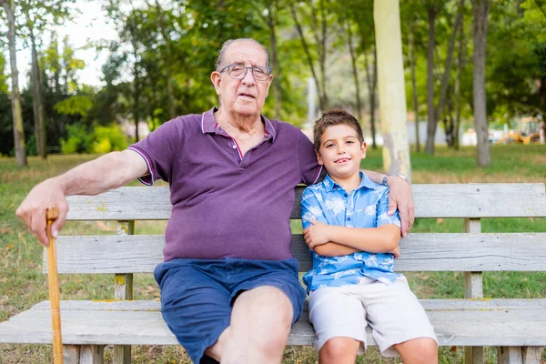 Grootvader Zijn Kleinzoon Zitten Een Bankje Het Park — Stockfoto