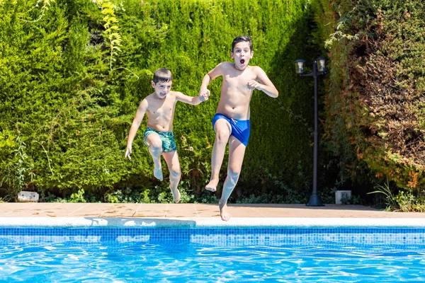 Dos Niños Saltando Una Piscina Día Soleado —  Fotos de Stock