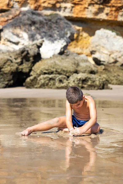 Pequeño Niño Sentado Una Playa Rocosa Fotos De Stock