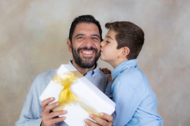 Küçük çocuk Babalar Günü 'nde babasına hediye veriyor.