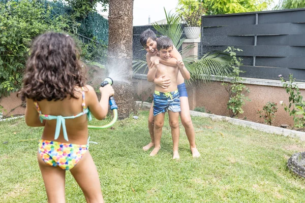 Três Crianças Engraçadas Brincando Com Uma Mangueira Jardim — Fotografia de Stock