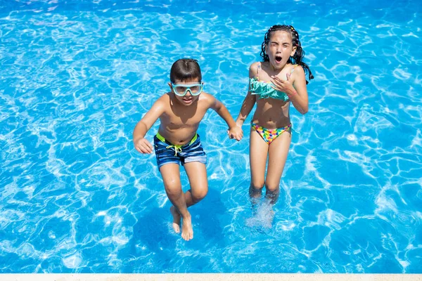 Dos Niños Saltando Una Piscina —  Fotos de Stock