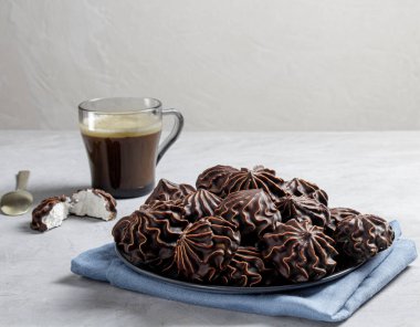 Gri keten bir bezin üzerinde bir fincan kahve ile marşmelov. Sevdikleriniz için en az şekerli bir akşam yemeği.